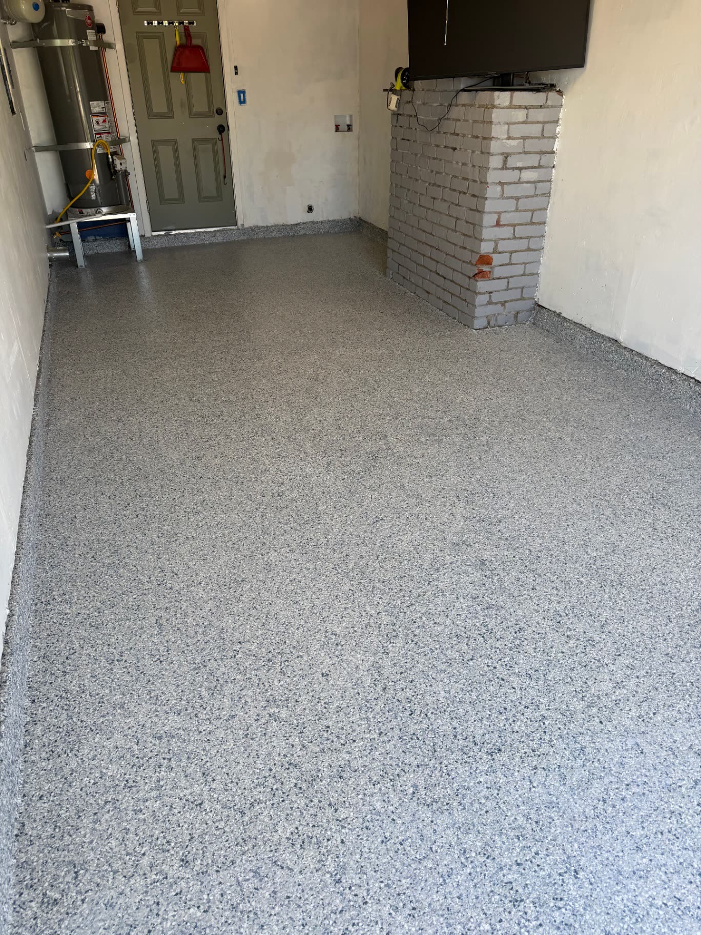 Finished gray flake epoxy garage floor with coved base in a Sacramento-area home