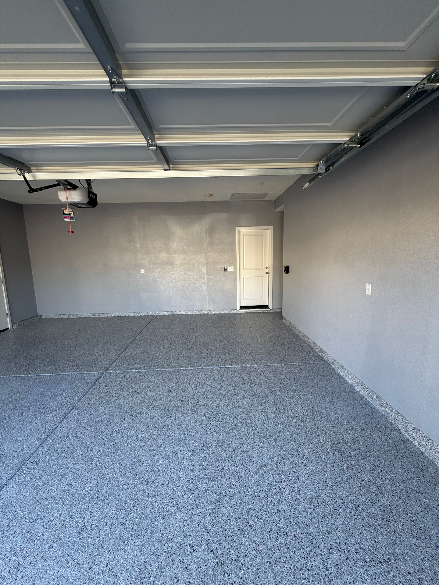 Completed two-car garage with gray flake epoxy floor and clean coved edges